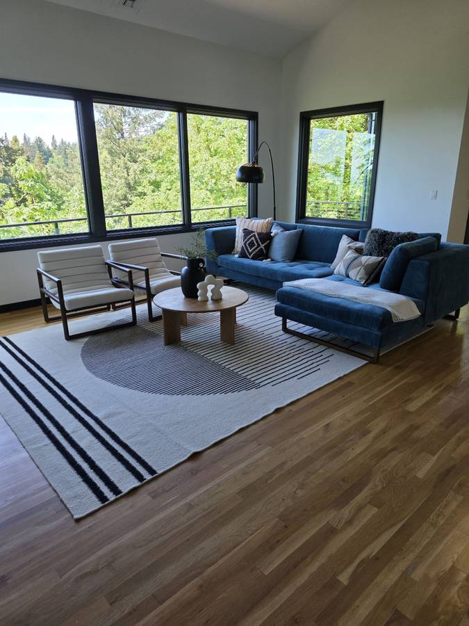 Living room with blue seating, large windows and clean wood floors from M&G’s gallery